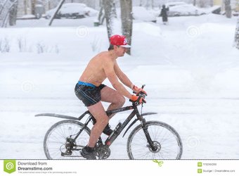 en-naken-man-rider-cykel-under-snöfall-i-vinter-moskva-110245099.jpg