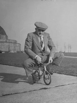 wallace-kirkland-humorous-of-man-riding-tiny-bicycle_u-l-p3myf00.webp