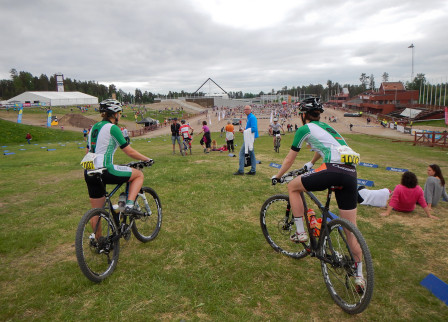 Två Falucyklister ser ut över Långa Lugnets startområde på Riksskidtadion.