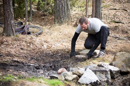 Trots att han egentligen tagit sin hand från själva bansträckningen hjälper Kung Stalle till en aning med att fylla igen ett lerhål på SS1 i Flottsbro. Foto: Bengt Luthman